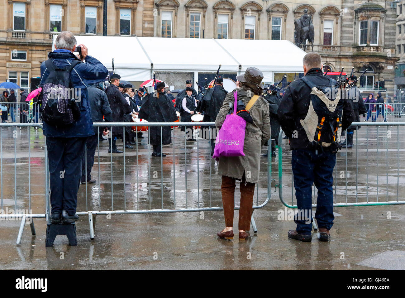 Glasgow, UK. 12. August 2016. Trotz starkem Regen und starkem Wind einige Touristen noch stellte sich heraus, dass die Pipe Bands, gab kostenlose Konzerte auf dem George Square und rund um die Innenstadt zu unterstützen. Die einwöchige Festival der Dudelsack Musik endet am Samstag mit dem spektakulären Welt Pipeband Meisterschaft, an der alle Bands. Credit: Findlay/Alamy leben Nachrichten Stockfoto