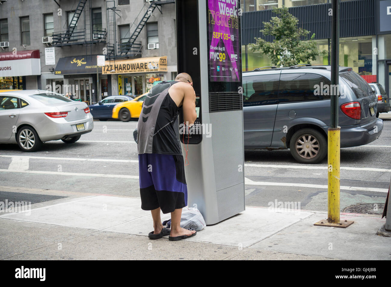 Ein Mann monopolisiert LinkNYC Kiosk, Musik hören, auf Samstag, 6. August 2016. Mehr als 7500 Kioske sind zu installierten ersetzen Stand allein Münztelefon Kioske bieten kostenfreies WLAN, Internet-Zugang über einen Touch-Screen, Telefon geladen und kostenlos telefonieren.  (© Richard B. Levine) Stockfoto