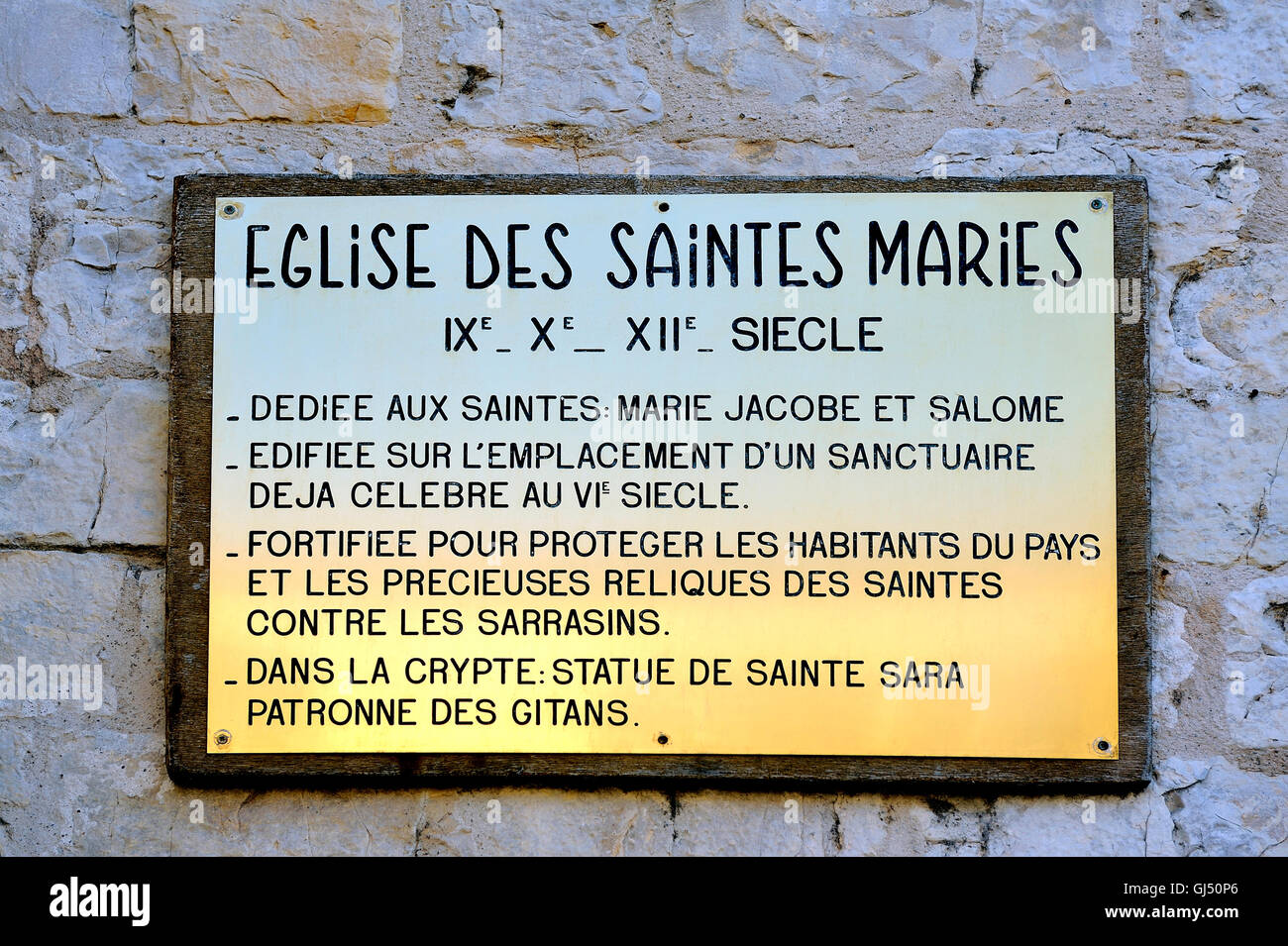 Plaque, erklärt die Geschichte von die Kirche von Saintes-Maries-de-la-Mer. Stockfoto