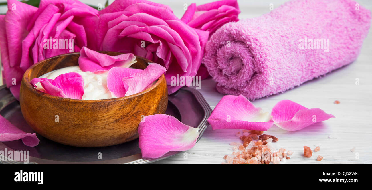 Wellness stieg Lotion mit Rosen, Blütenblättern und Handtuch Stockfoto