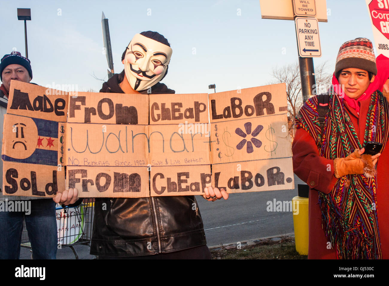 Chicago, Illinois - 29. November 2013: Mann trägt eine anonymen Maske protestiert vor einem Walmart-Geschäft zur Unterstützung der Streikenden am schwarzen Freitag. Stockfoto