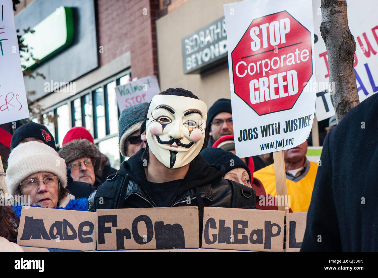 Chicago, Illinois - 29. November 2013: Mann trägt eine anonymen Maske protestiert vor einem Walmart-Geschäft zur Unterstützung der Streikenden am schwarzen Freitag. Stockfoto