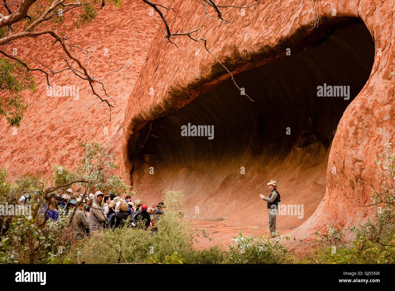 Ein Ranger mit einer Gruppe von Touristen auf dem Mala Walk am Uluru im Uluru-Kata Tjuta National Park. Stockfoto