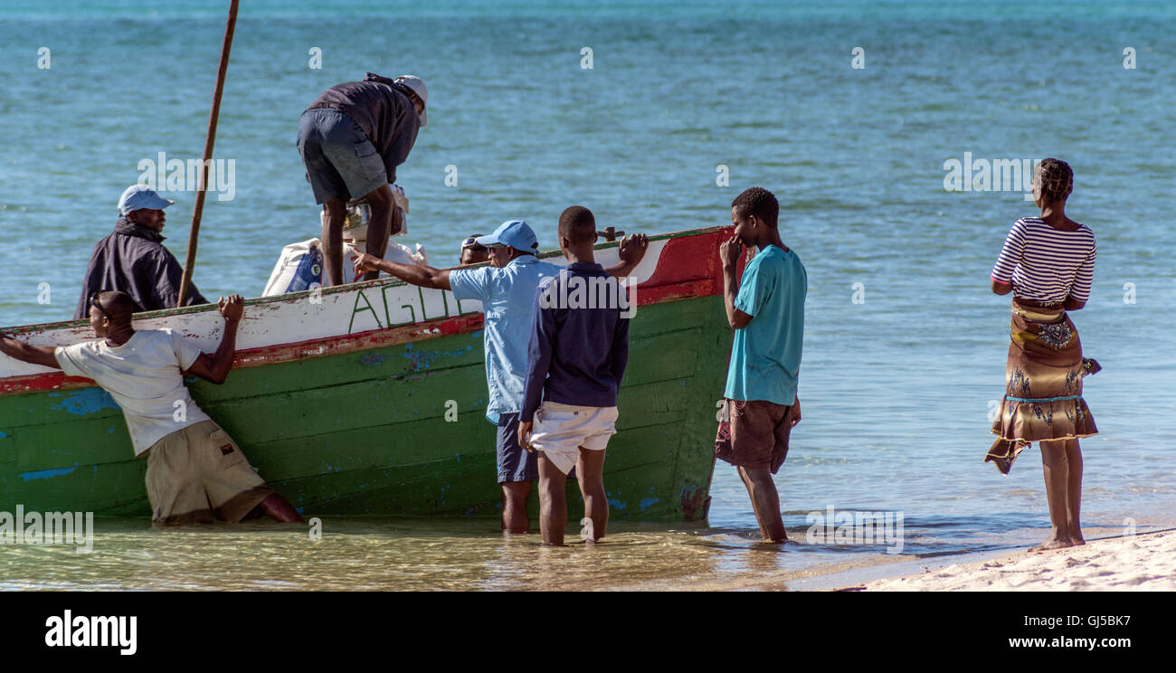 Einheimischen Entladen einer Dhau Bestimmungen am Strand von Benguerra Insel Mosambik Stockfoto