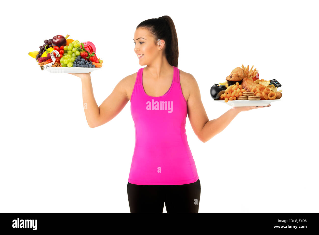 Gesunde oder ungesunde Lebensweise Konzept junge Frau mit zwei Platten von Lebensmitteln eine ungesunde aber suchen an gesunde Platte Stockfoto