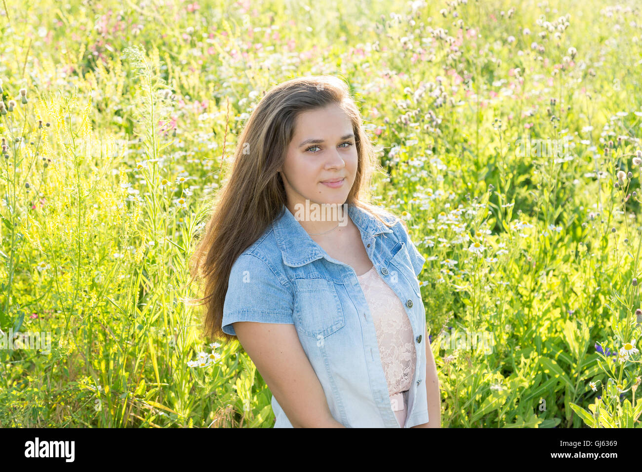 15-jährige Mädchen mit langen braunen Haaren auf Sommer Waldwiese Stockfoto