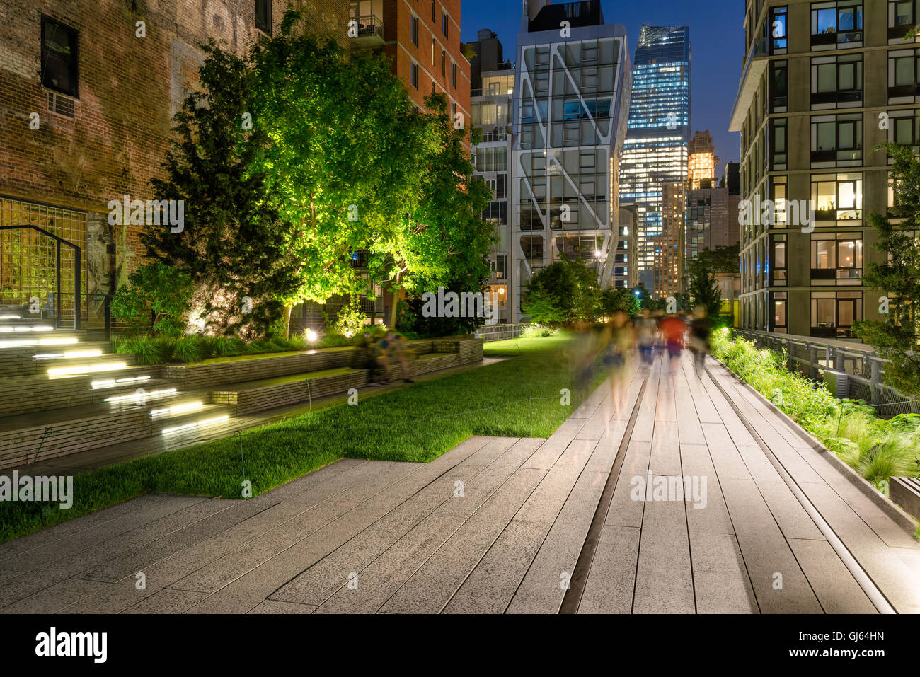 Die High Line-Promenade beleuchtet in der Dämmerung umgeben von modernen und Altbauten in Chelsea, Manhattan, New York City Stockfoto