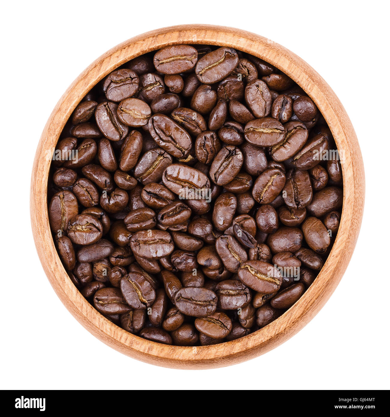 Arabica Kaffeebohnen in einer Holzschale auf weißem Hintergrund. Unpulverized gebratene braune Gruben der Kaffeekirschen. Stockfoto