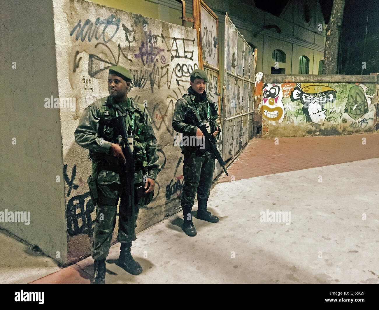 Bewaffnete Militär patrouillieren die Straßen außerhalb der Osteingang zum Olympischen Leichtathletik Veranstaltungsort, Joao Havelange Stadium. Stockfoto