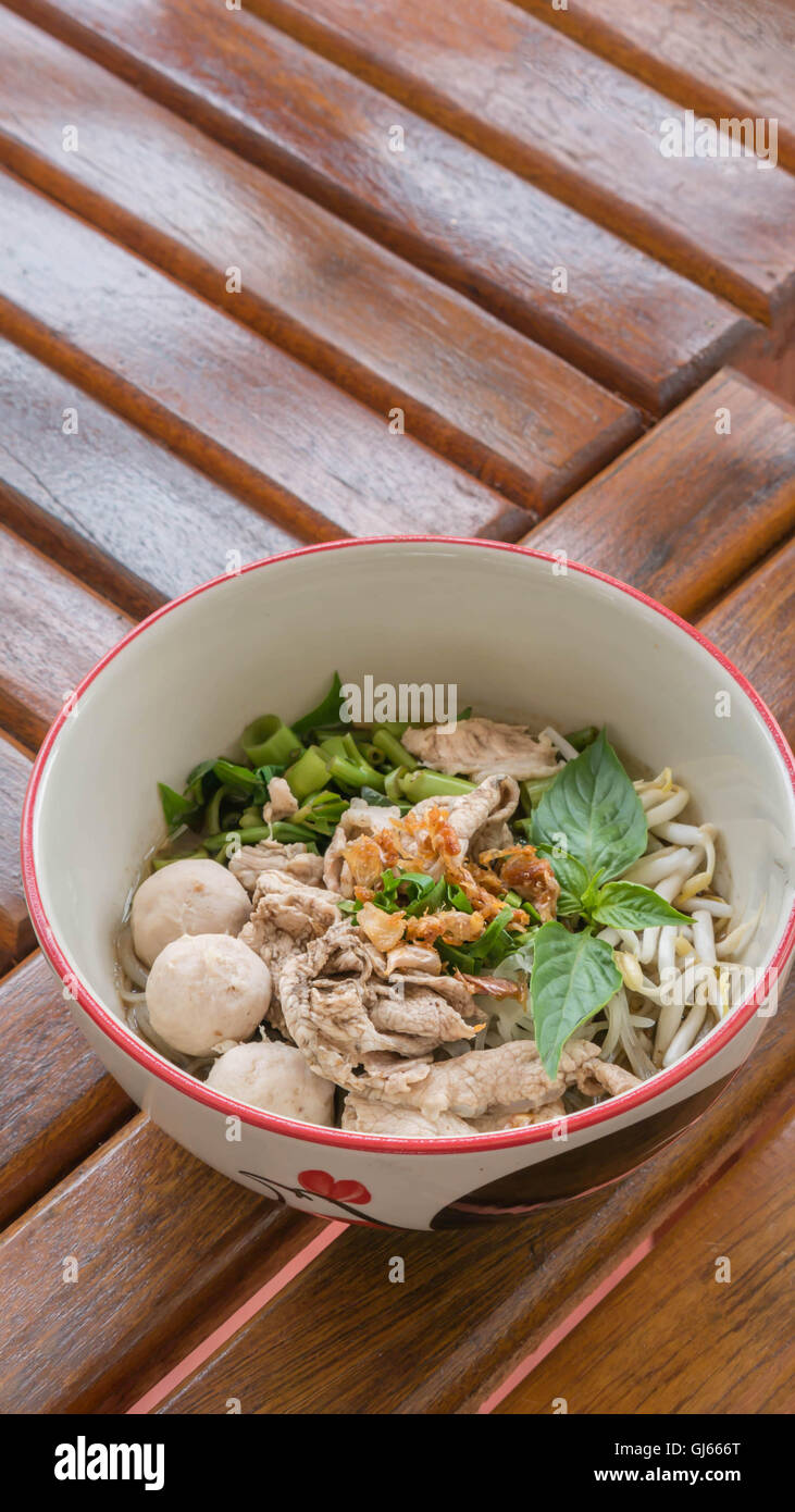 Asiatische weiße Nudeln mit Schweinefleisch und Gemüse in Schüssel über hölzerne Hintergrund Stockfoto