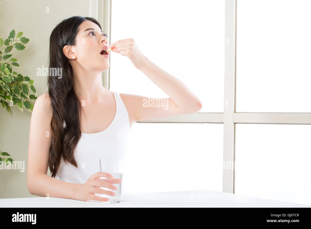 schöne asiatische Frauen Essen Ernährung Fischöl Ergänzung für gesunde Ernährung zu Hause Stockfoto