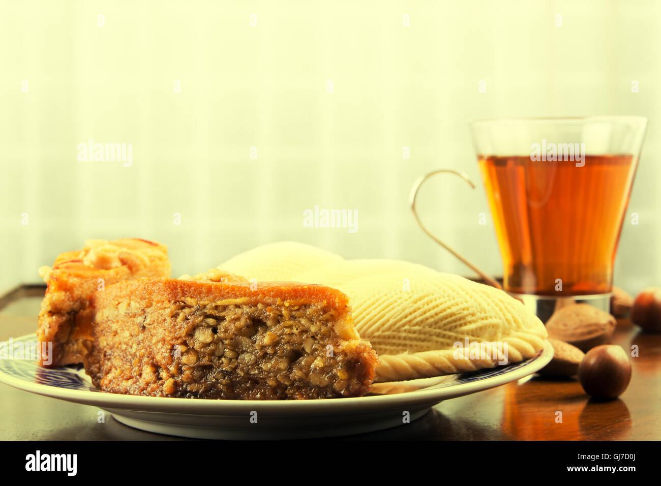 Traditionelle östliche süßes Gebäck Shekerbura und Baklava, Tasse Tee und Nüssen auf Café-Tisch oder alten Couchtisch. Getönten Bild Stockfoto