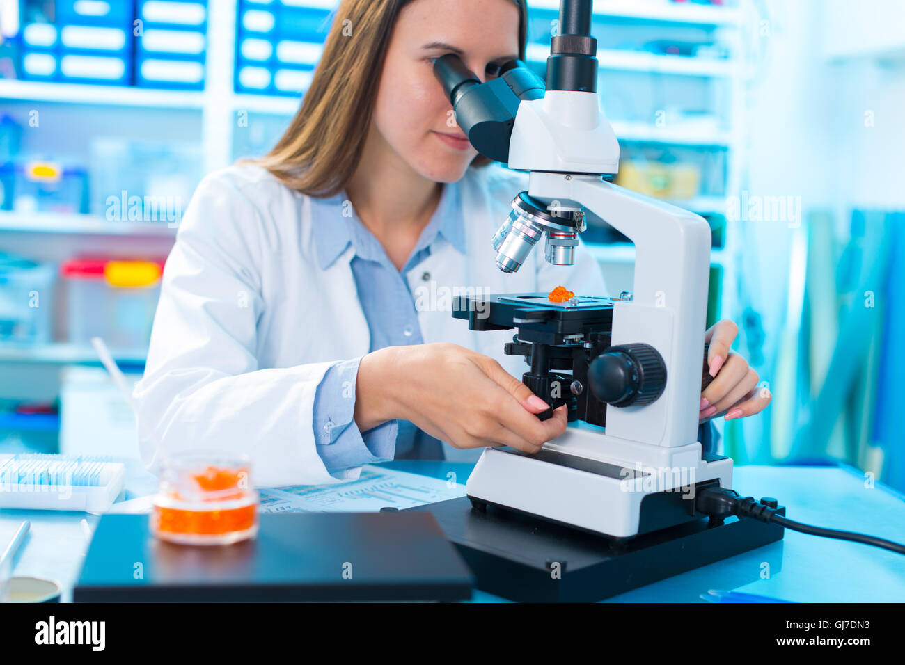 Qualitätskontrolle von Lebensmitteln. Junge Frau im chemischen Labor Test von rotem Kaviar Stockfoto