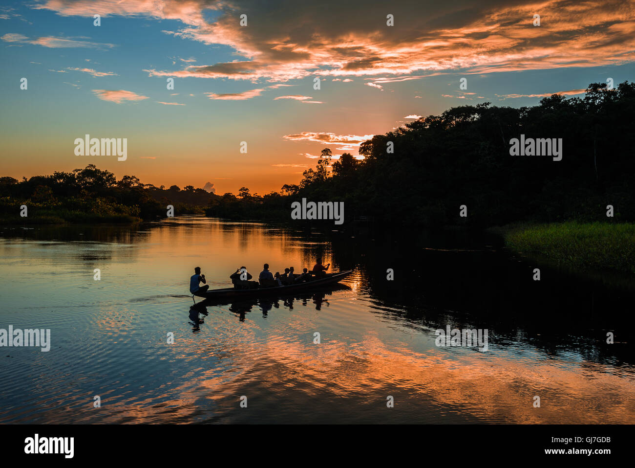 Ein Kanu mit Touristen über Amazon bei Sonnenuntergang paddeln. Yasuni-Nationalpark in Ecuador, Südamerika. Stockfoto
