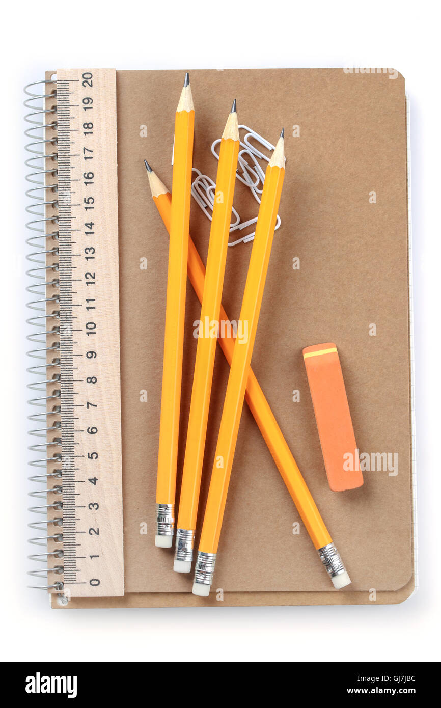 Notebook, Radiergummi, Lineal, Bleistift und Büroklammern auf weißem Hintergrund Stockfoto