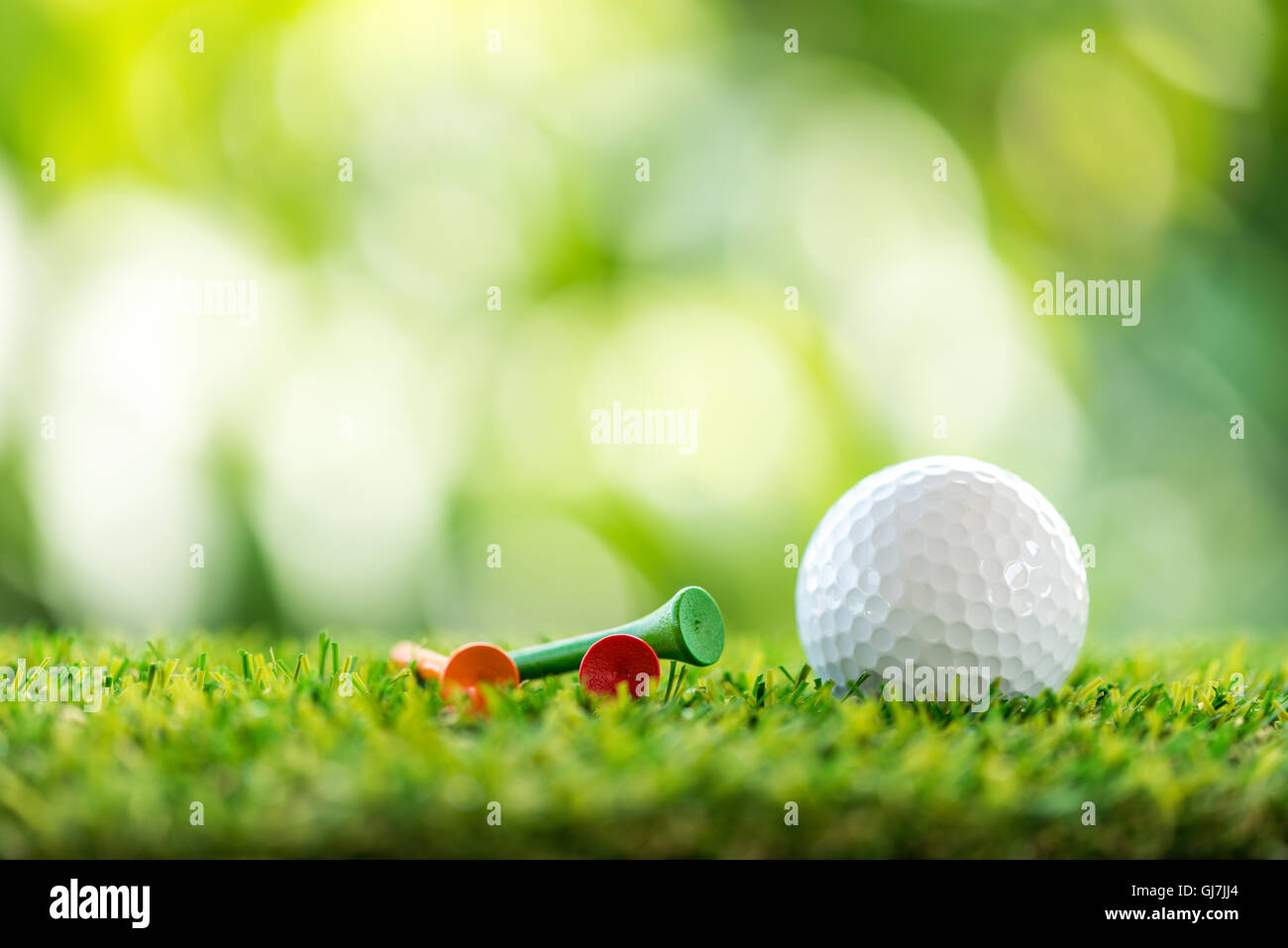 Golfball und hölzernen Abschlag auf dem Rasen Stockfoto