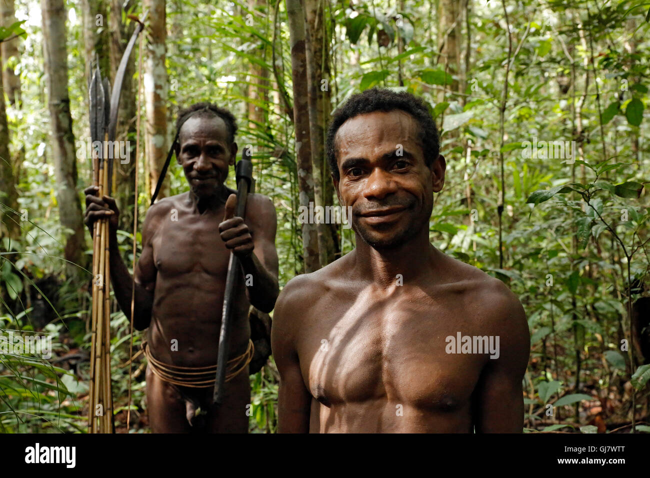 Zwei Männer von den nomadischen Wald Stamm Korowai, stehend im Wald. Papua, Indonesien Stockfoto
