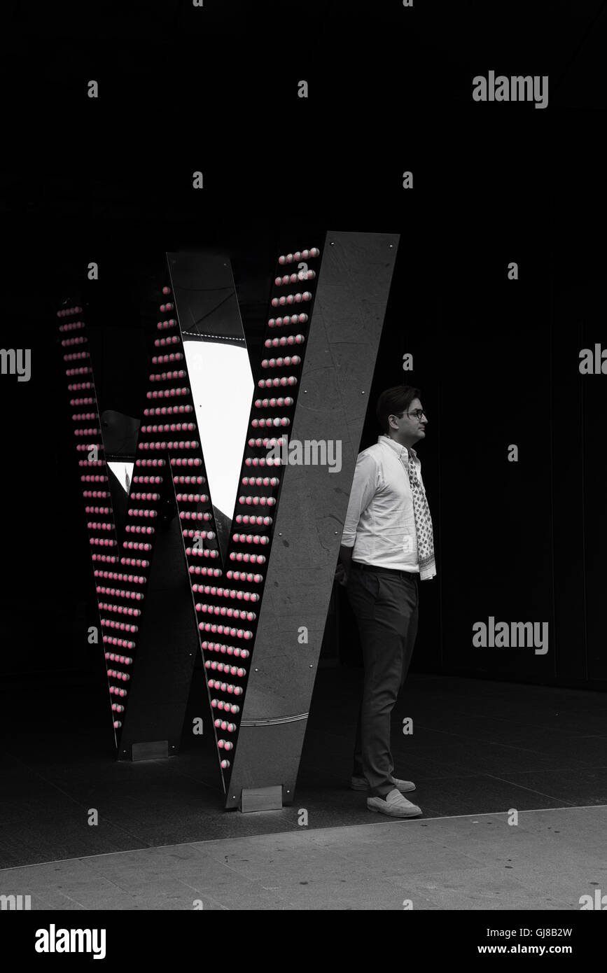 Mann stand neben M & M Welt Gebäude in Leicester Square in London - Männerwelt Stockfoto