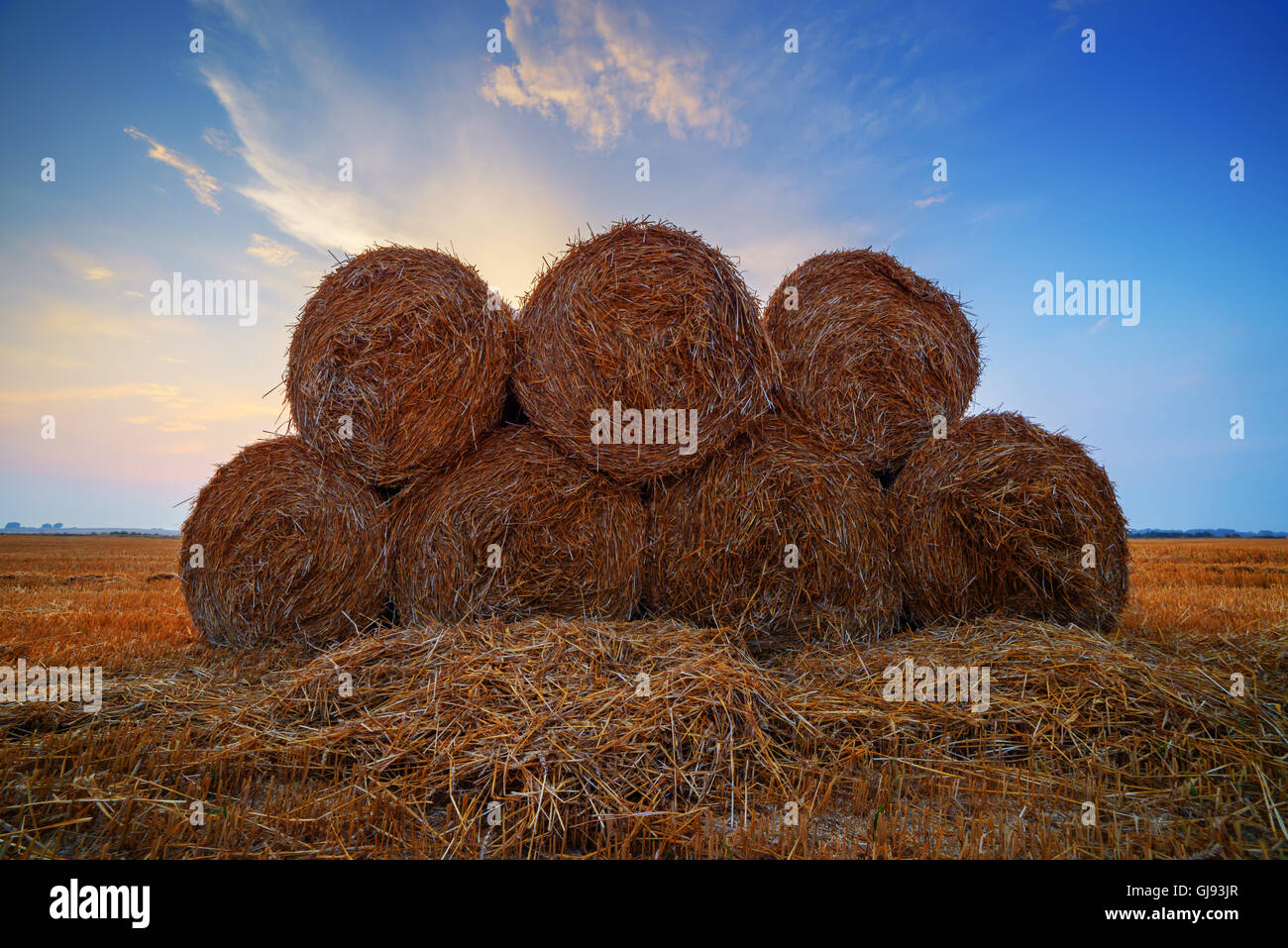 Erstaunliche Ländliches Motiv auf Herbst Feld mit Stroh Rollen und dramatische Abendlicht. Stockfoto