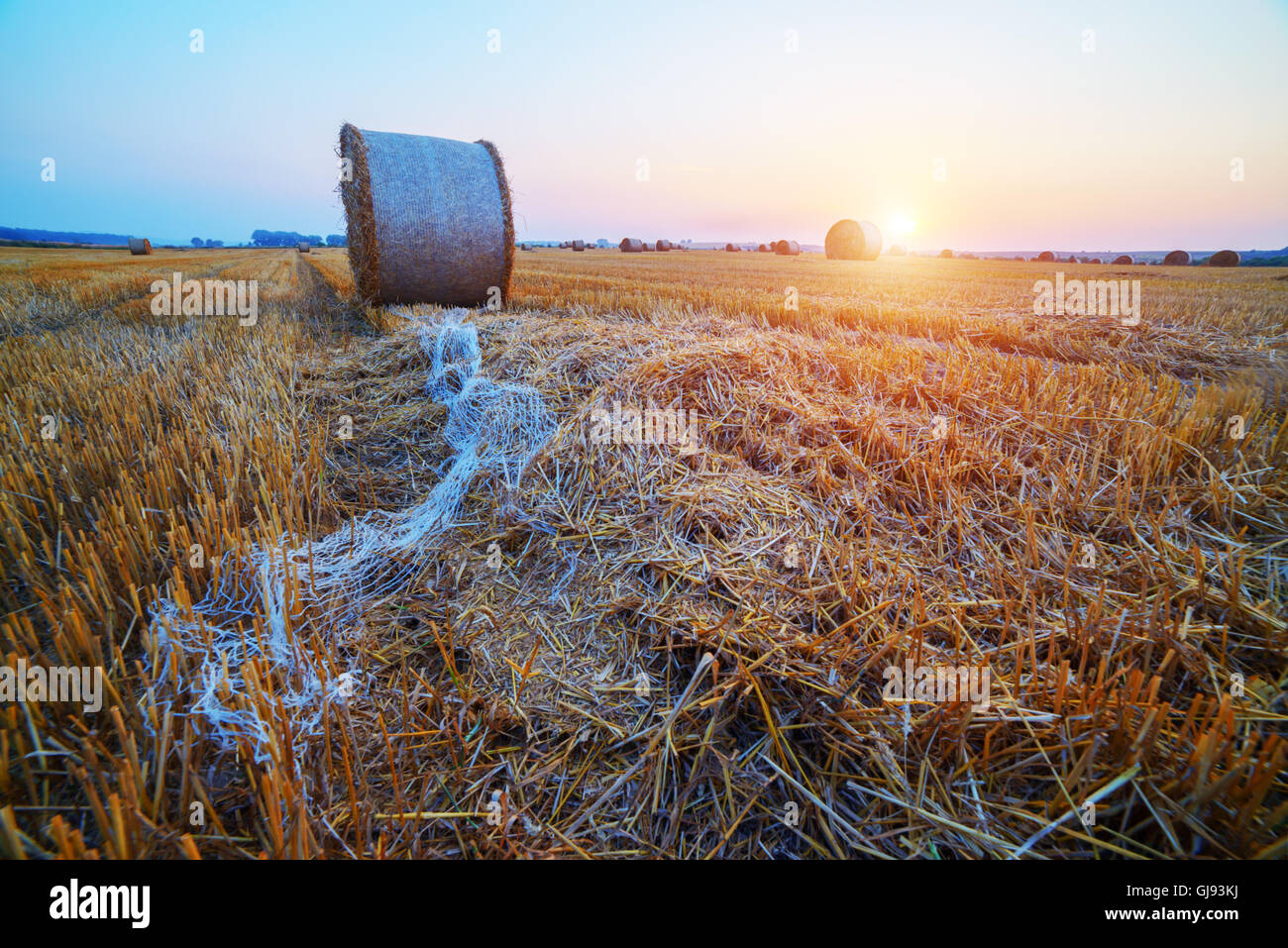 Erstaunliche Ländliches Motiv auf Herbst Feld mit Stroh Rollen und dramatische Abendlicht. Stockfoto