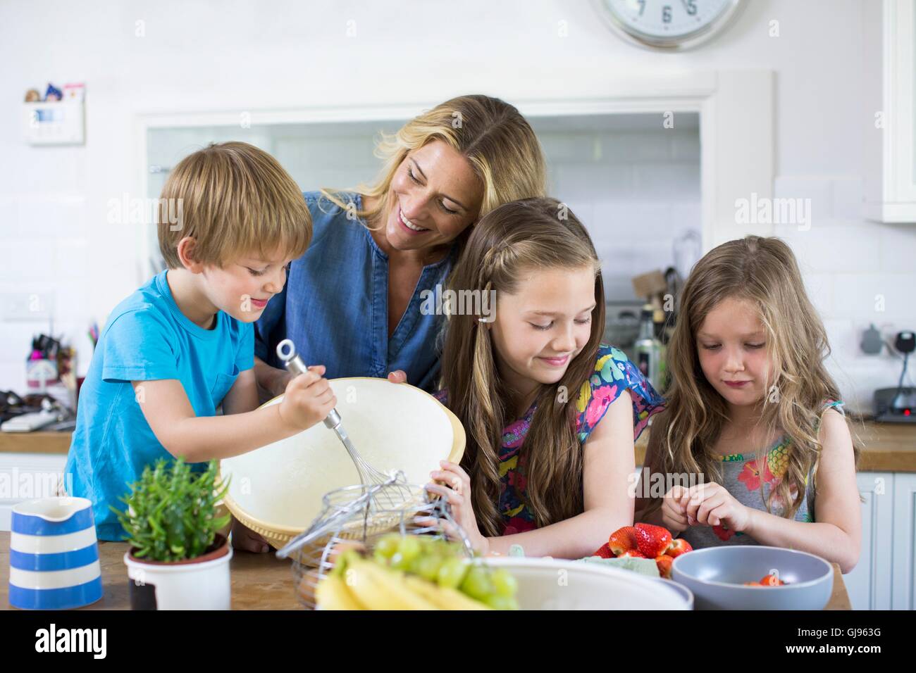 EIGENTUM FREIGEGEBEN. -MODELL VERÖFFENTLICHT. Mutter und Sohn und Töchter Kochen in der Küche. Stockfoto