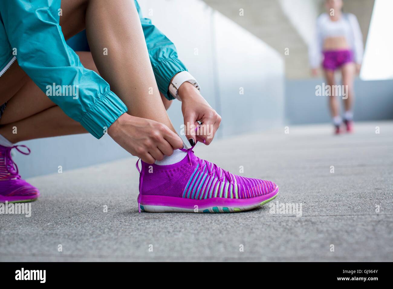 -MODELL VERÖFFENTLICHT. Frau auf Trainer Schnürsenkel zu binden. Stockfoto