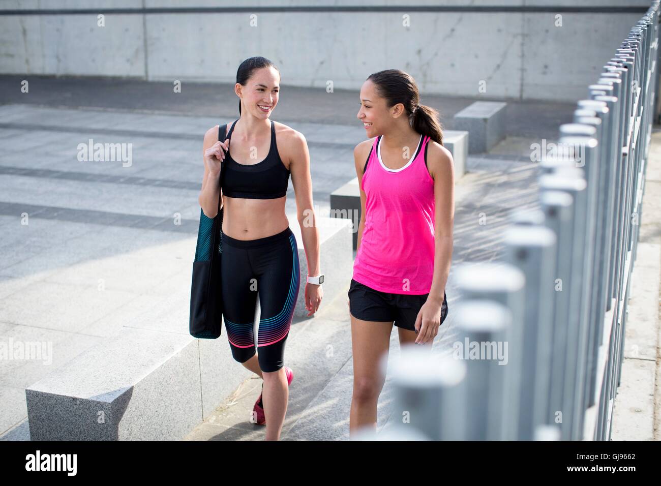 -MODELL VERÖFFENTLICHT. Zwei junge Frauen im Sport Kleidung, Lächeln. Stockfoto