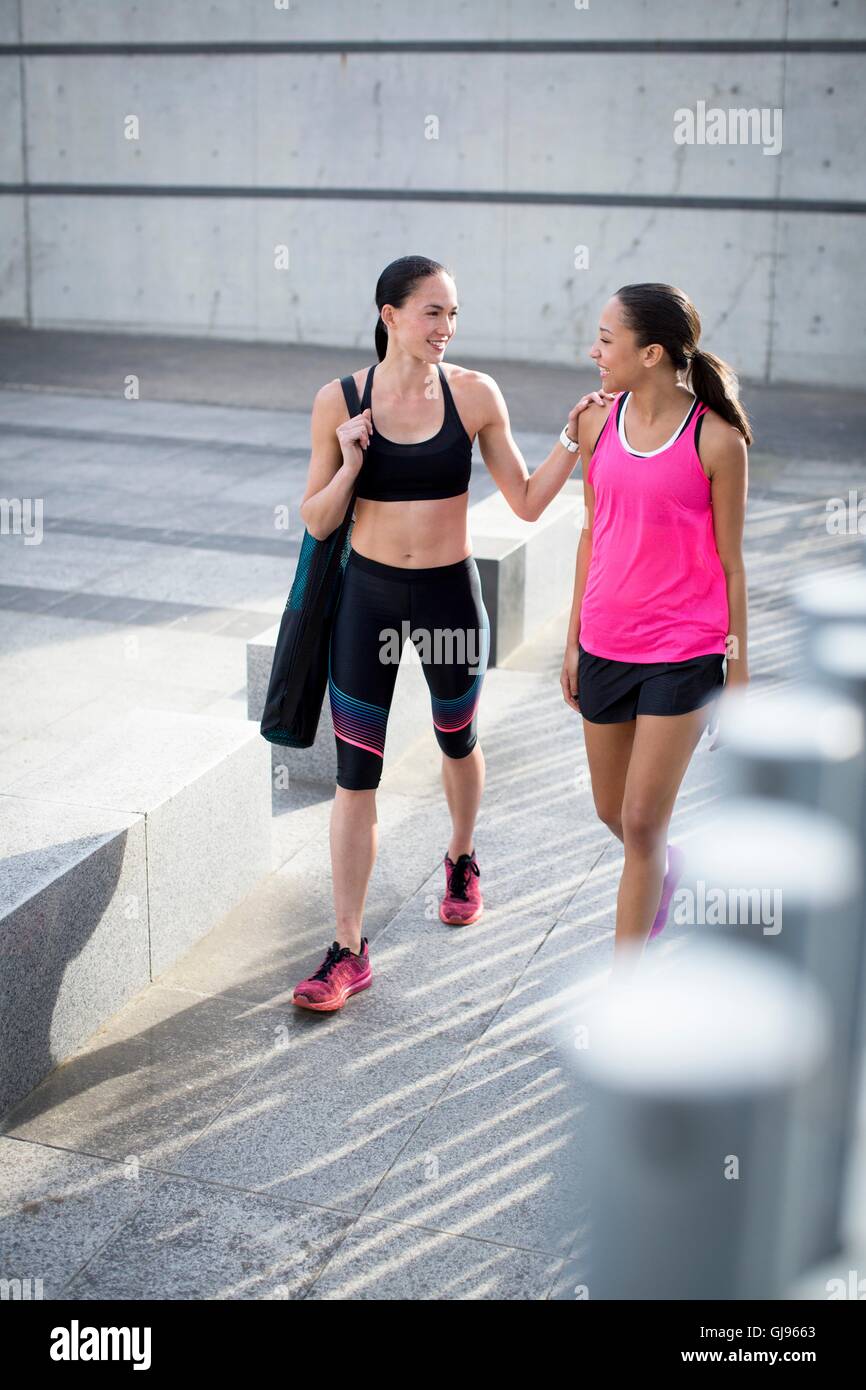-MODELL VERÖFFENTLICHT. Zwei junge Frauen im Sport Kleidung, Lächeln. Stockfoto