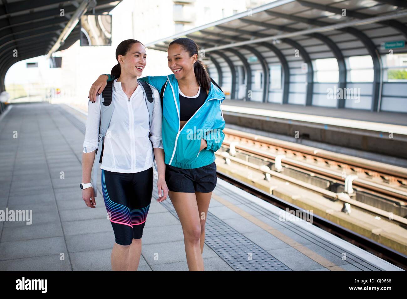 -MODELL VERÖFFENTLICHT. Zwei junge Frauen in Sportbekleidung auf Bahnsteig. Stockfoto