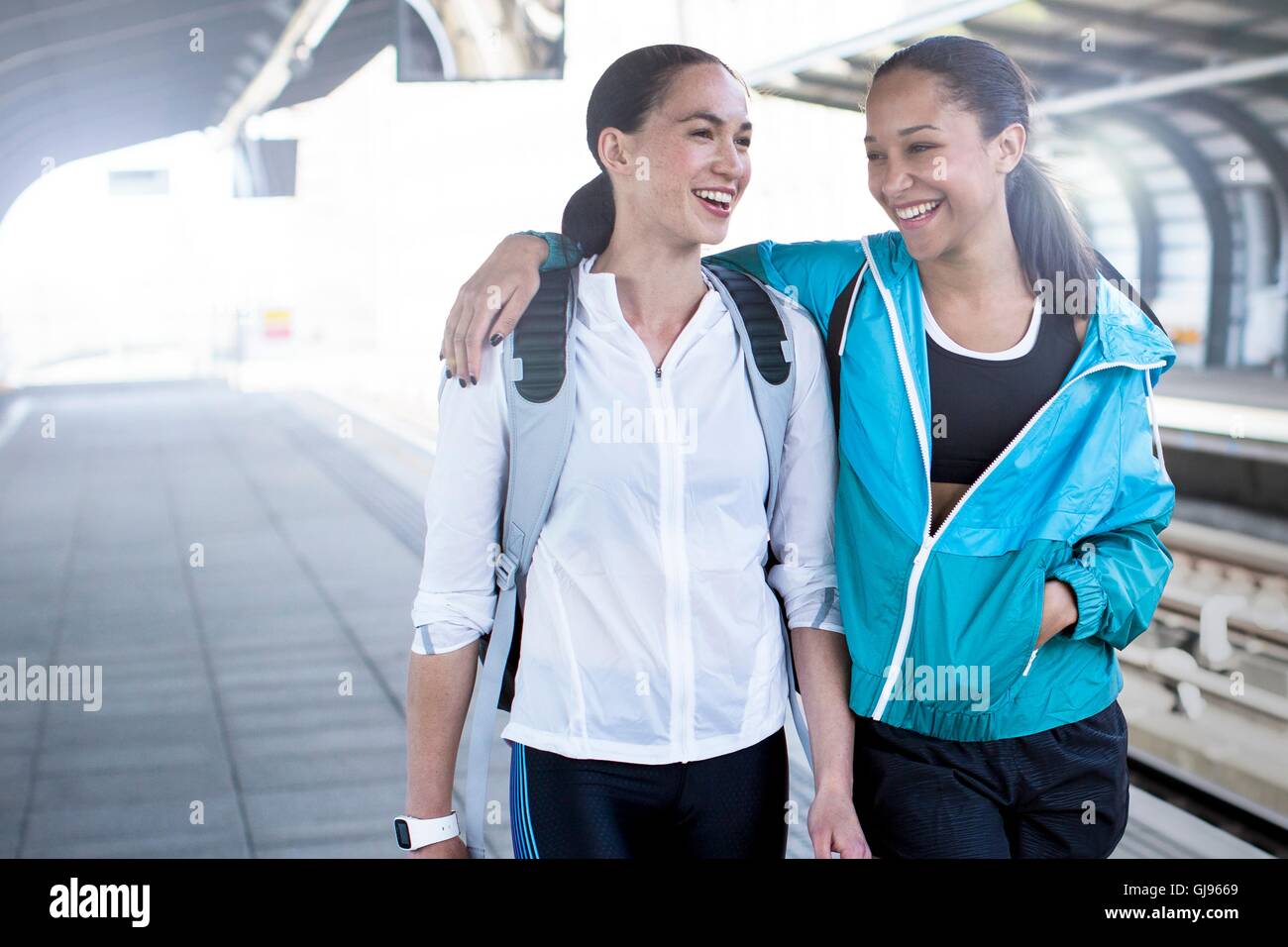 -MODELL VERÖFFENTLICHT. Zwei junge Frauen in Sportbekleidung auf Bahnsteig. Stockfoto