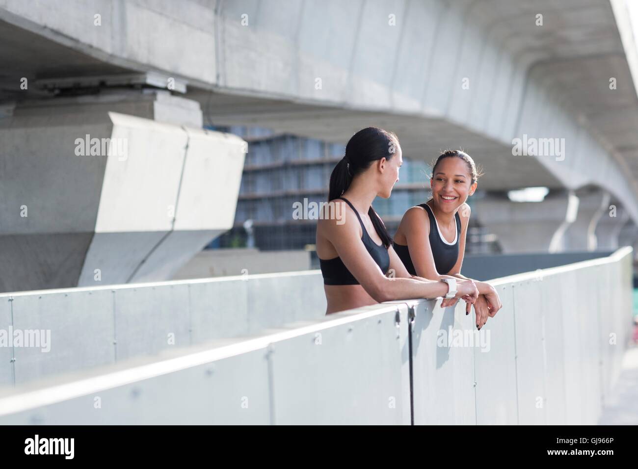 -MODELL VERÖFFENTLICHT. Zwei junge Frauen, stützte sich auf die Wand in Sportbekleidung. Stockfoto