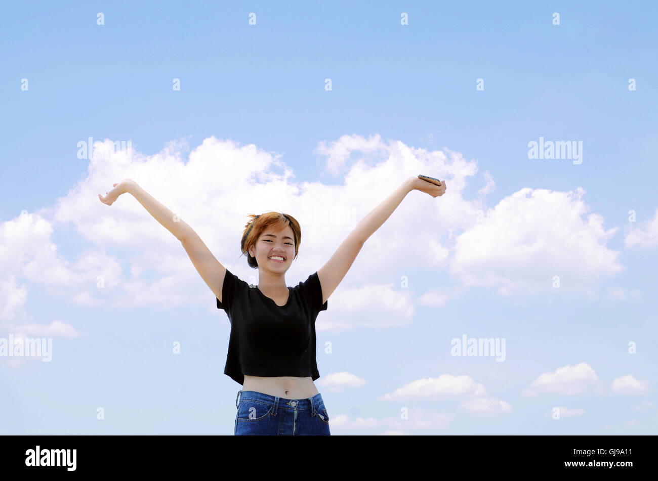 Glückliches Mädchen auf blauen Himmelshintergrund. Stockfoto