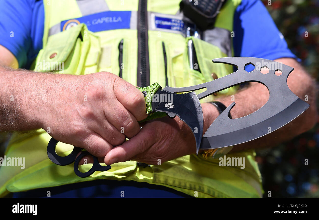 Sperrfrist bis Montag 15. AUGUST 0001 West Midlands PCSO Rob Capella hält zwei Beispiele für "Zombie-Messer" an einem sicheren Polizei-Standort in Birmingham als eine geänderte Gesetz bedeutet, dass ab nächsten Donnerstag, wer produziert, verkauft, vermietet, importiert oder verleiht ein "Zombie-Messer" ein Verbrechen und Gesichter sechs Monate hinter Bars und/oder einer Geldbuße begeht. Stockfoto