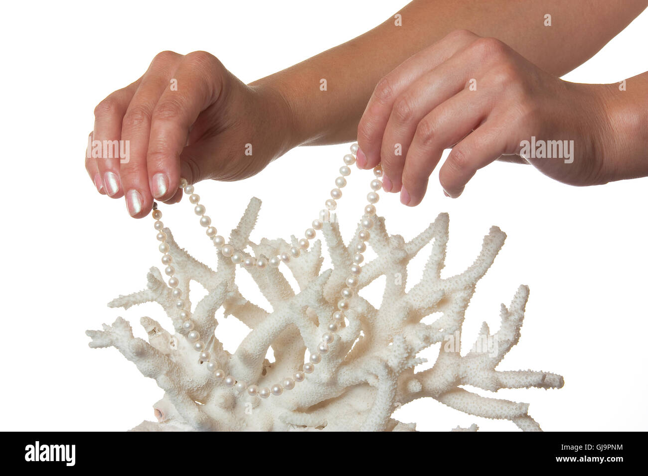 eine Perlenkette in die Hände vor dem Hintergrund der Korallen Stockfoto