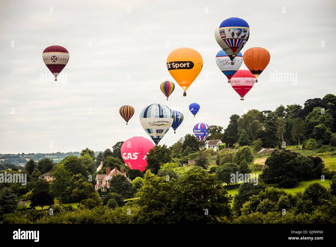 Heißluftballons fliegen über dem Ashton Gericht Nachlass nach dem Start in einem Masse Aufstieg an der Bristol International Balloon Fiesta. Stockfoto