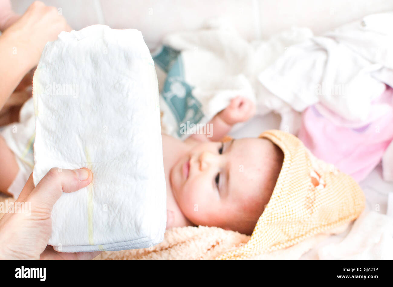 elterliche Hand hält Stapel Windeln Baby am Wickeltisch Stockfoto