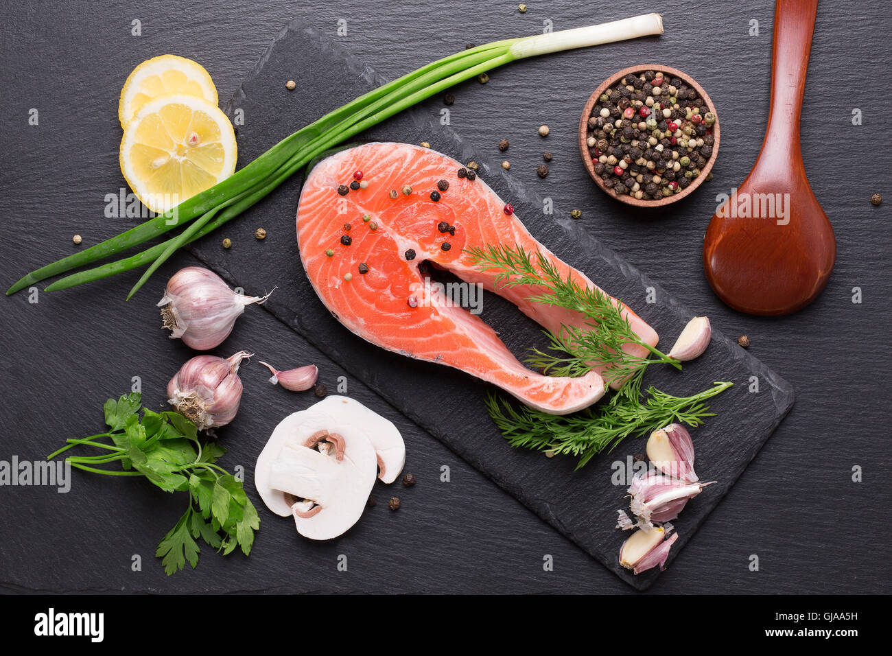 roter Fisch Steak mit Gewürzen und Gemüse auf einem Schiefer Tisch. Stockfoto