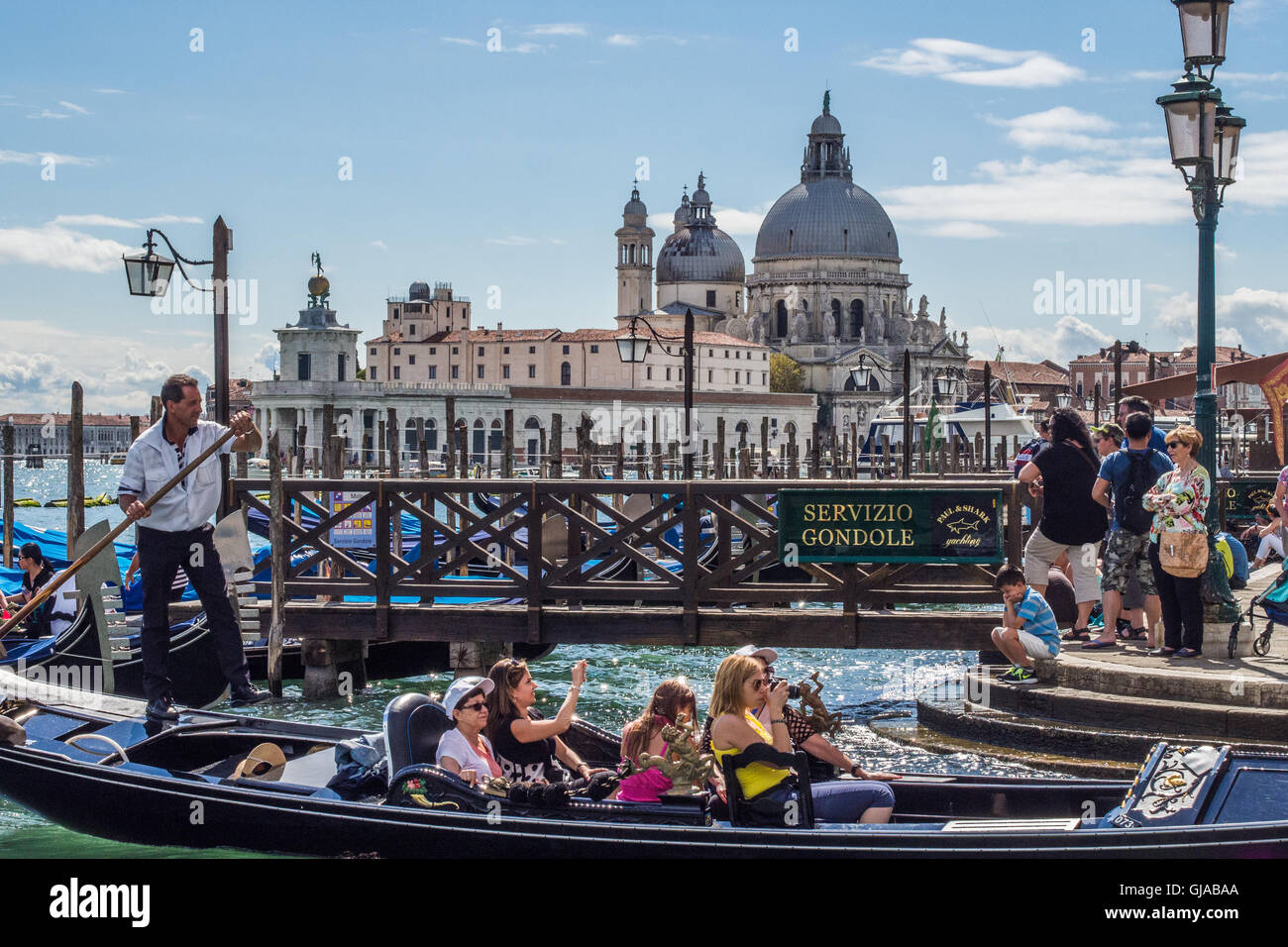 Gondelfahrt in Venedig, mit der Kirche Santa Maria della Salute hinter, Venetien, Italien. Stockfoto