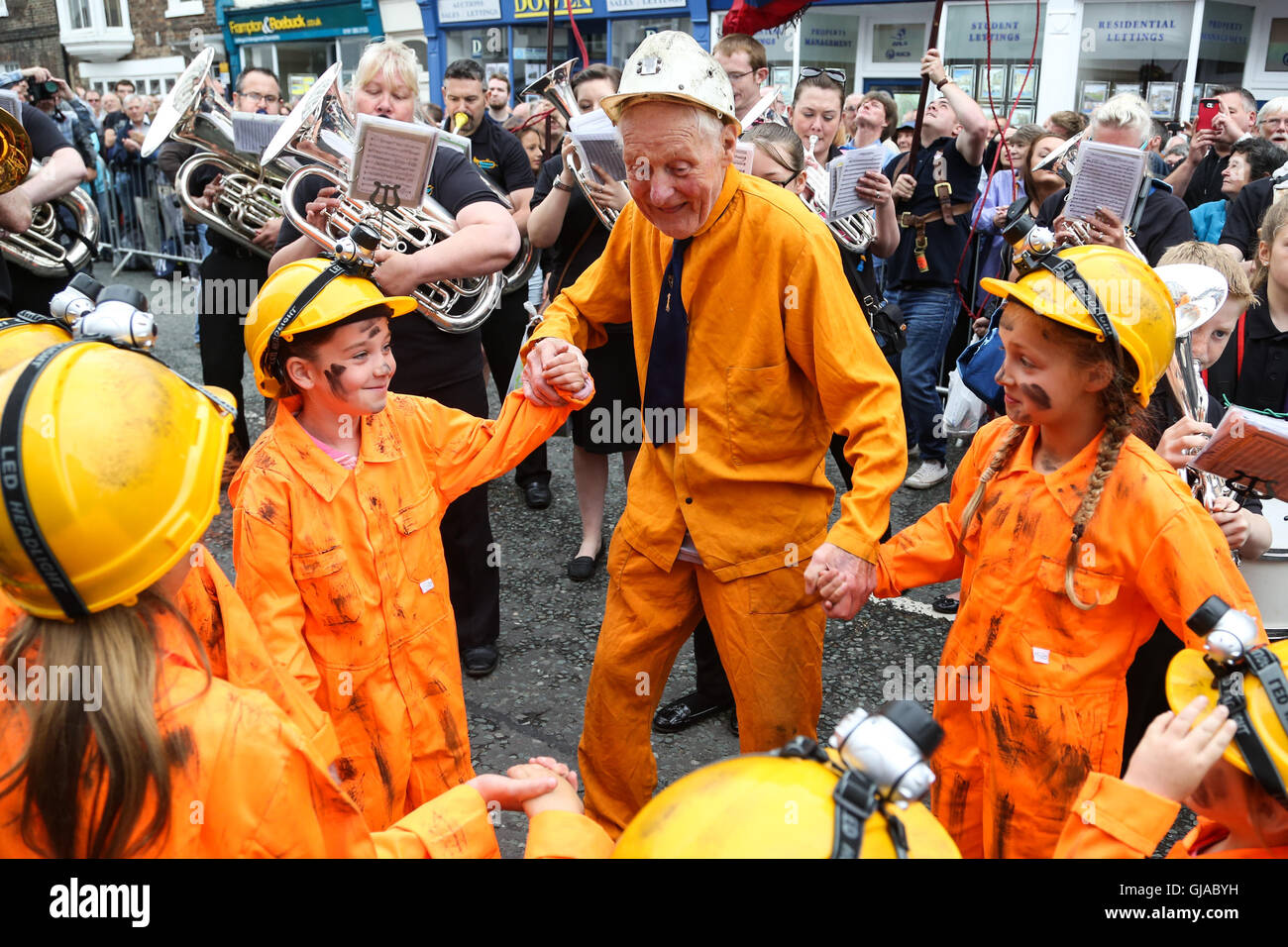 Durham, Großbritannien. Ein ehemaliger Bergmann tanzt zu den Brass Bands mit vier jungen Mädchen. Stockfoto