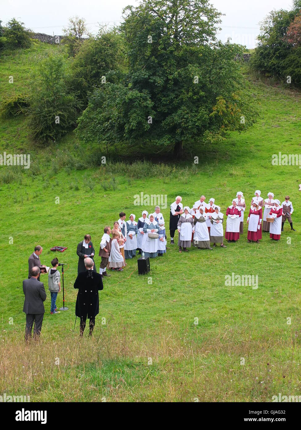 Dorfbewohner in Kostümen führen der Eyam Pest Gedenken Service im Cucklet Delf Stockfoto