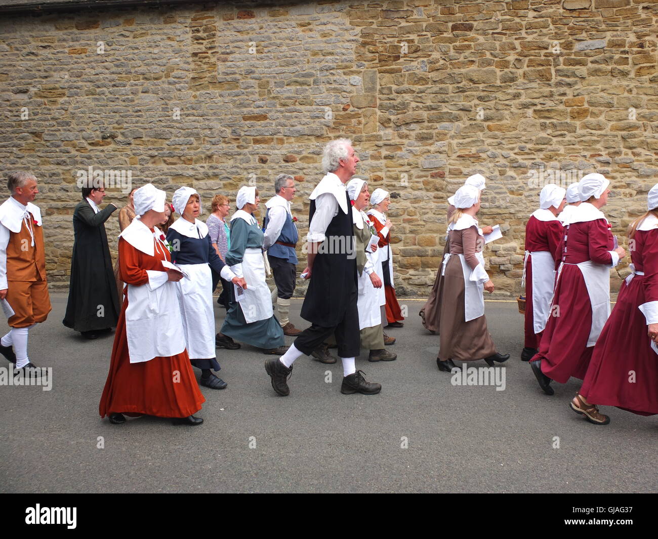 Kostümierte Dorfbewohner Fuß durch die Straßen von Eyam in des Dorfes Pest Gedenken Jahresservice Stockfoto