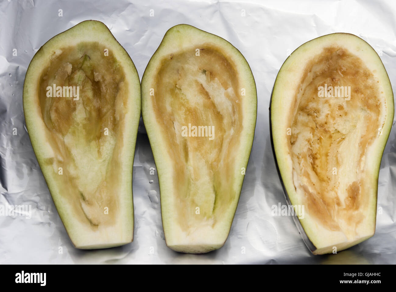 Hälften der Rohe Auberginen bereit für eine Füllung auf das Backblech. Ansicht von oben. Stockfoto