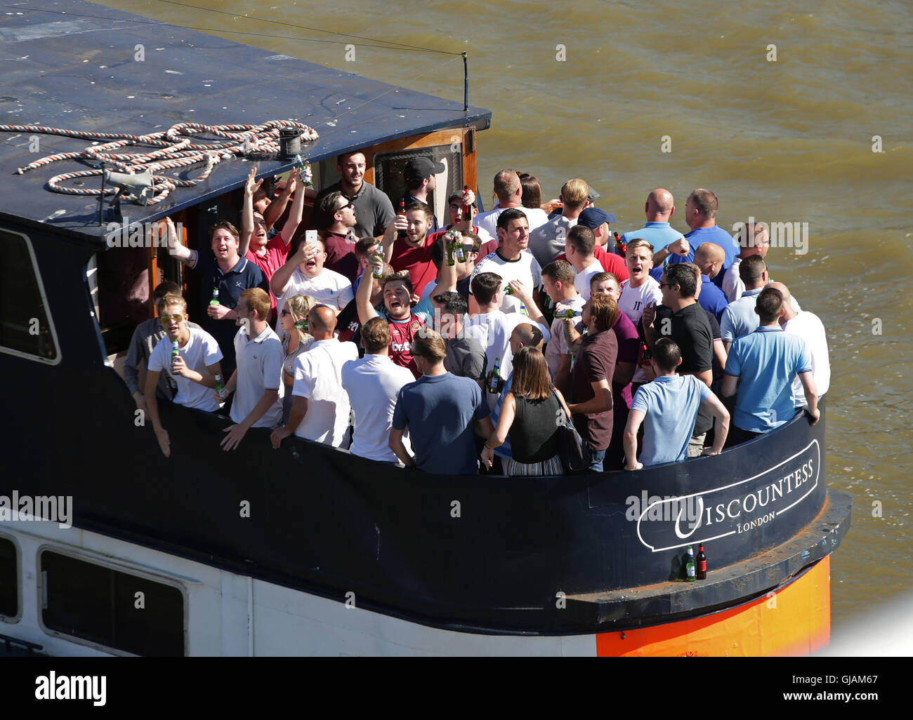 Fußball-Fans auf einem Kreuzfahrt-Boot unterqueren die Millennium Bridge an der Themse, während ein Zauber von heißem Wetter in London. RESS Verein Foto. Bild Datum: Montag, 15. August 2016. Bildnachweis sollte lauten: Yui Mok/PA Wire Stockfoto