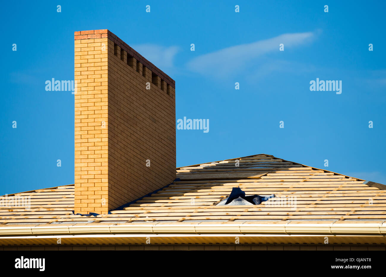 Dach unter Konstruktionen mit vielen Fliesen und gelben Backstein-Schornstein Stockfoto