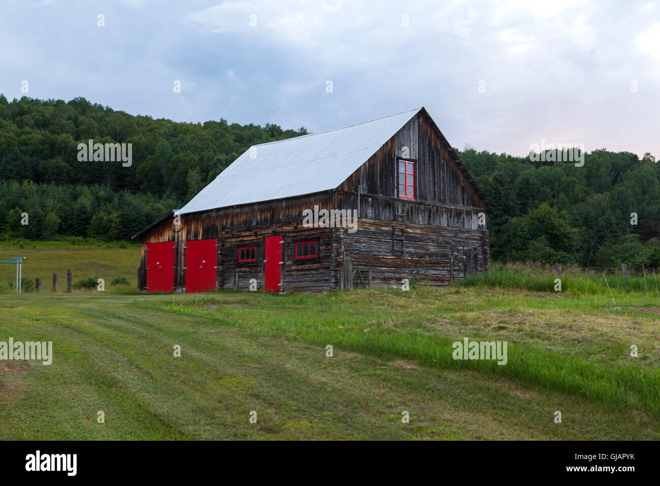 Scheune mit roten Türen und Fenstern in Quebec Stockfoto