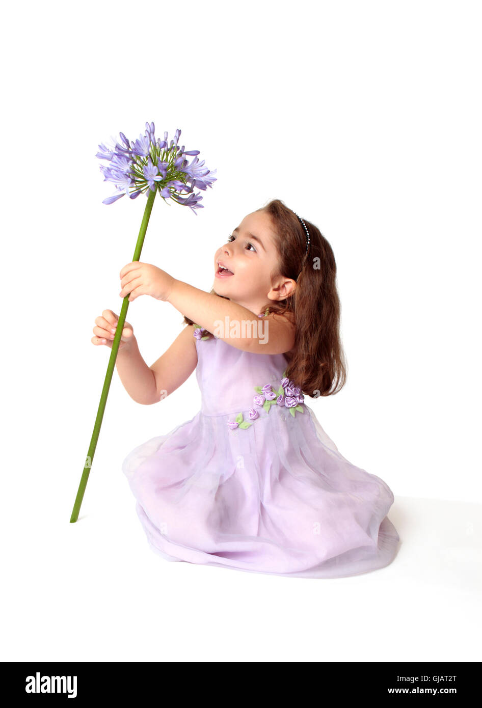 Kleines Mädchen Spinnen eine große stemmed Blume mit Freude Stockfoto