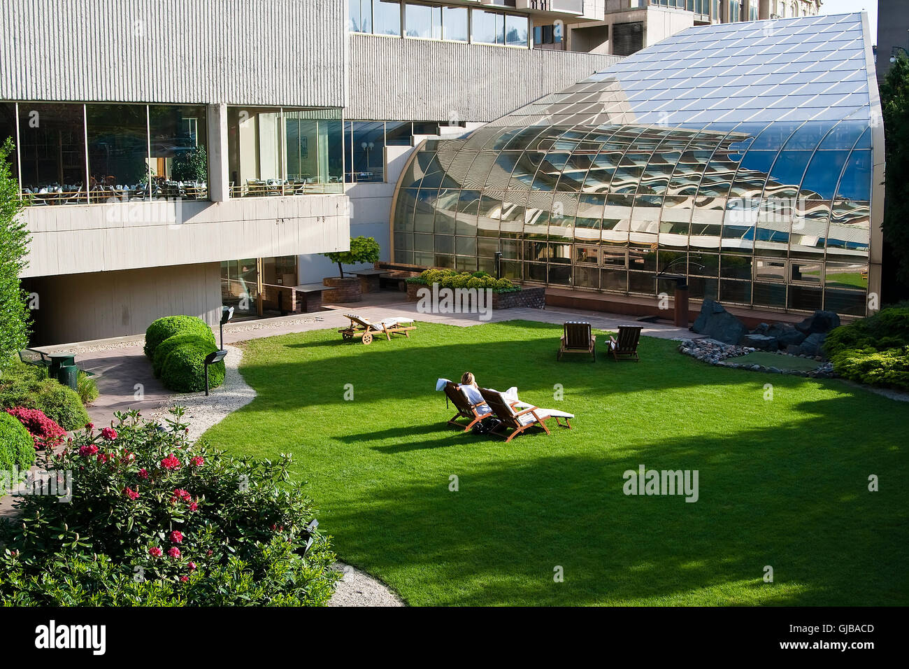 Zone der Ruhe und Entspannung in einem modernen Hotel im Zentrum Stadt. Sonnenliegen und grünen Rasen Stockfoto