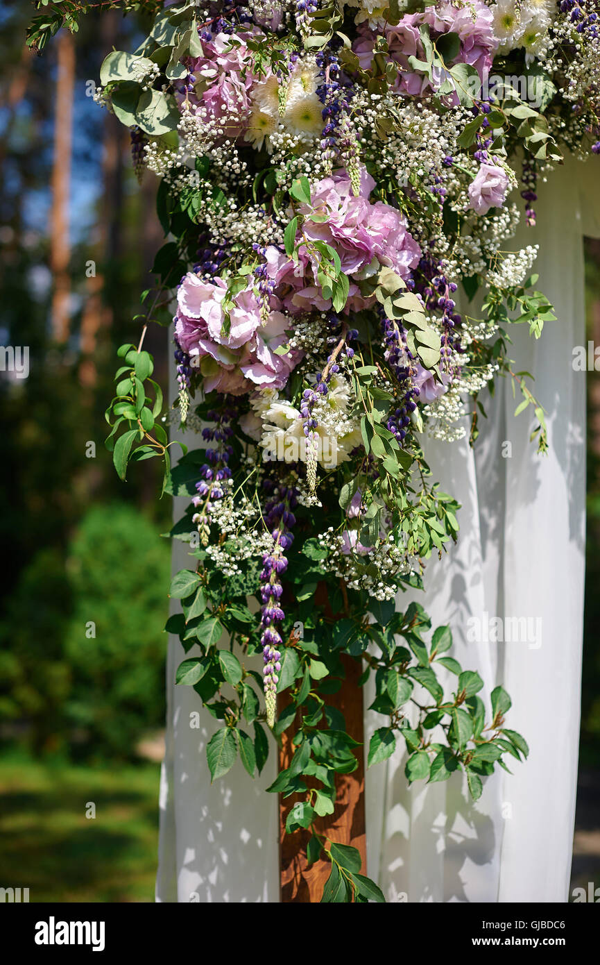 Hochzeit Bogen dekoriert mit Blumen und Glas Vasen hängen Stockfoto
