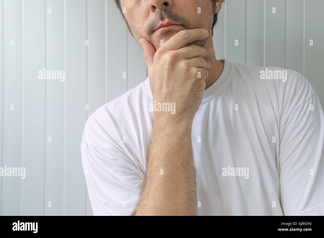 Mann mit Hand am Kinn, tiefe Gedanken und harte Entscheidungen Stockfoto