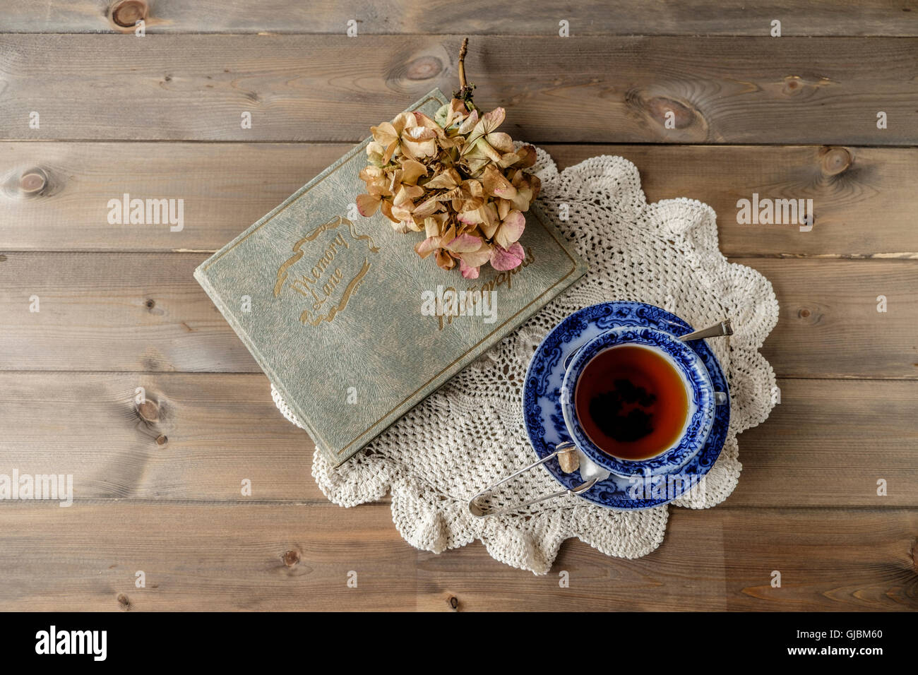 Top-down-lay-flat-Bild der Antike China-blauen und weißen Tasse und Untertasse mit Memory Lane Fotoalbum mit Lace-Tuch auf Holz Stockfoto